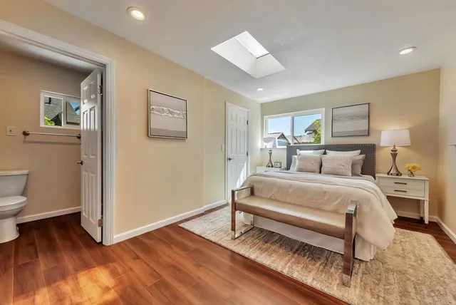 a spacious bedroom with a bed and a painting on the wall