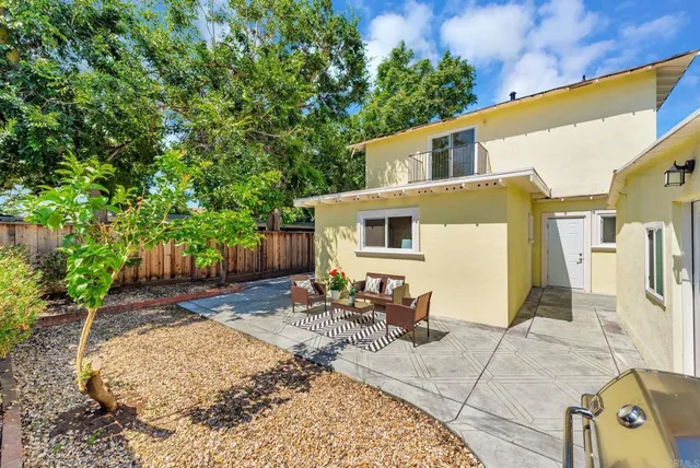 a backyard of a house with table and chairs