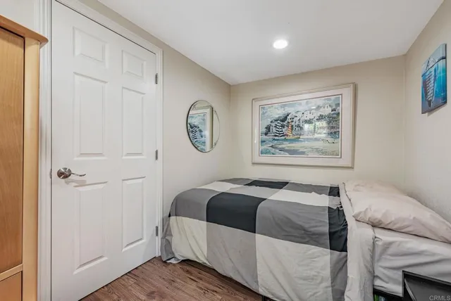 a bedroom with a bed and a painting on the wall