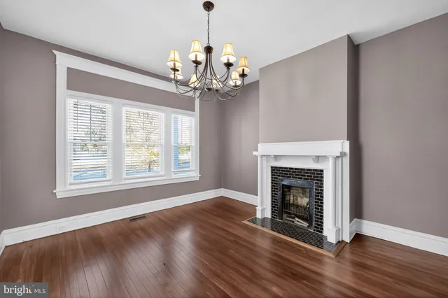 a view of a livingroom with a fireplace chandelier and wooden floor