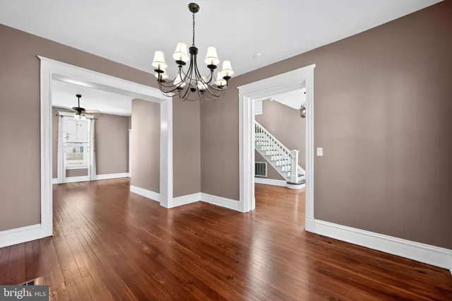 a view of a hallway with wooden floor and chandelier