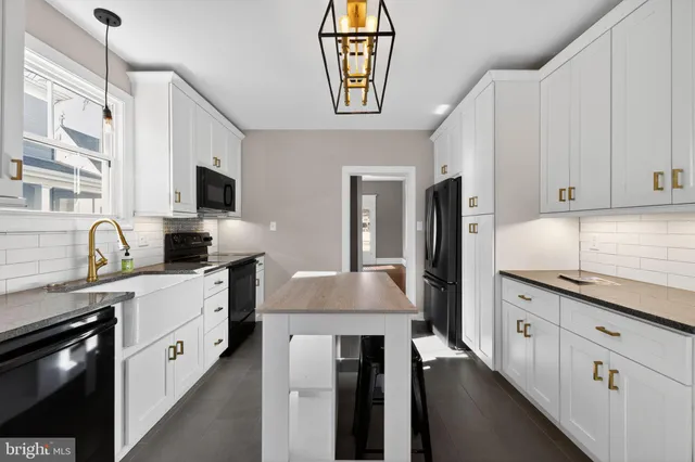 a large white kitchen with stainless steel appliances granite countertop a stove a sink and a refrigerator