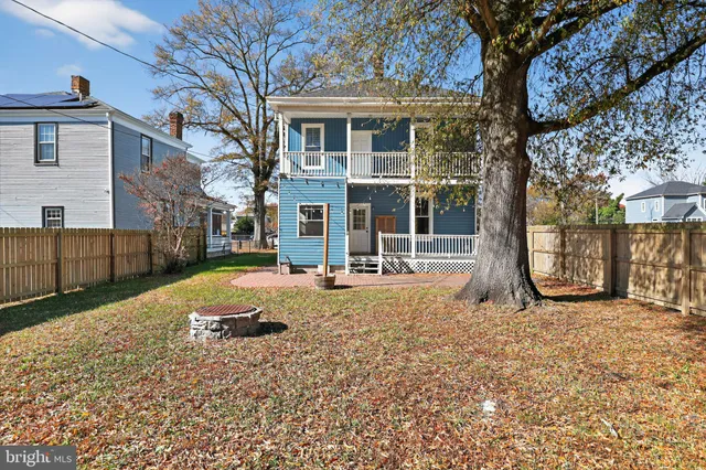 a view of a house with a small yard and large tree