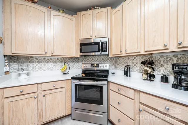 a kitchen with granite countertop white cabinets and white appliances