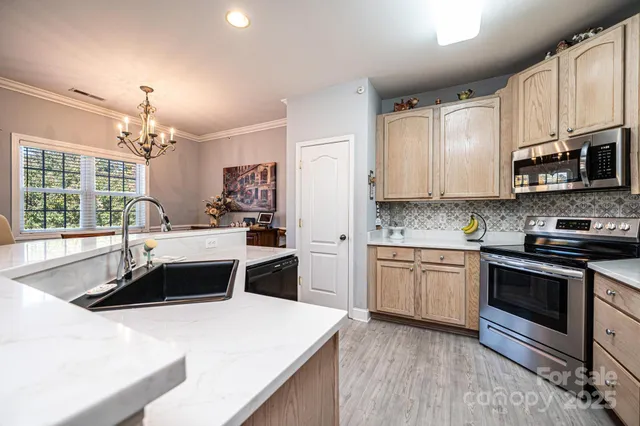 a kitchen with stainless steel appliances kitchen island granite countertop a stove sink and microwave