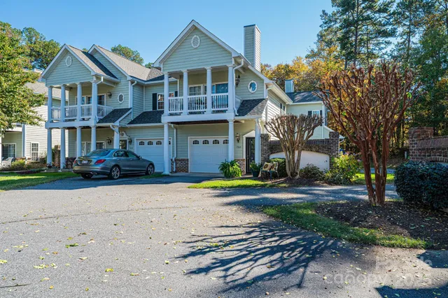 a front view of a house with a yard and lake view