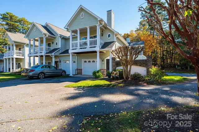 a front view of a house with a yard outdoor seating and lake view