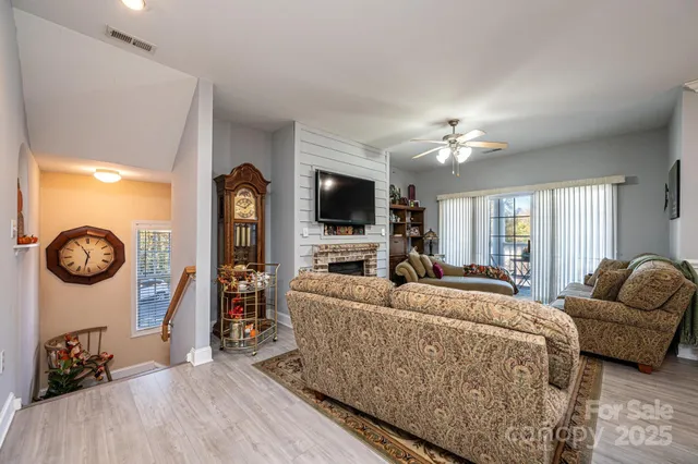 a living room with furniture a flat screen tv and a large window