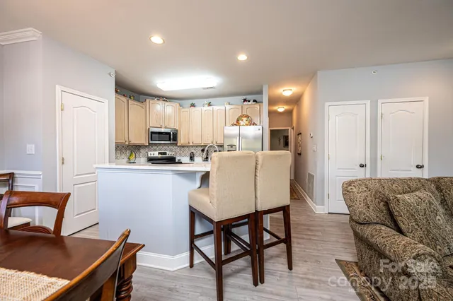 a living room with stainless steel appliances kitchen island granite countertop furniture and a kitchen view