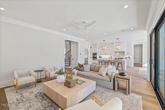 a kitchen with stainless steel appliances kitchen island granite countertop a dining table chairs and white cabinets