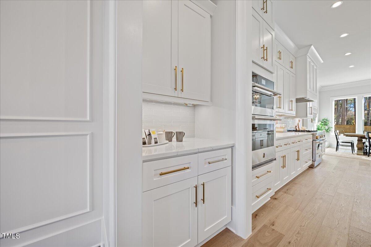 4906 Tremont Drive Raleigh, NC 27609 - Photo 19 of 71 a kitchen with white cabinets and white appliances