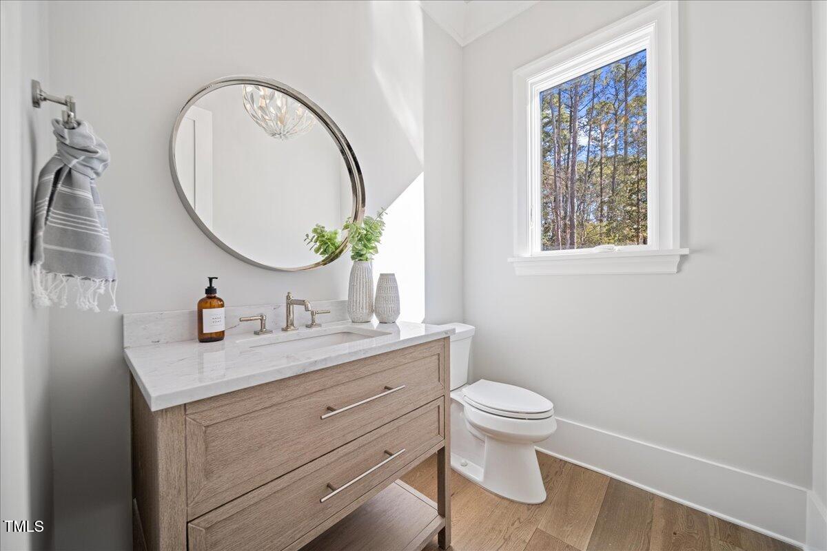 4906 Tremont Drive Raleigh, NC 27609 - Photo 24 of 71 a bathroom with a granite countertop toilet a sink and a mirror