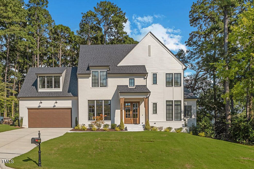 4906 Tremont Drive Raleigh, NC 27609 - Photo 4 of 71 a view of a white house with a big yard and large trees