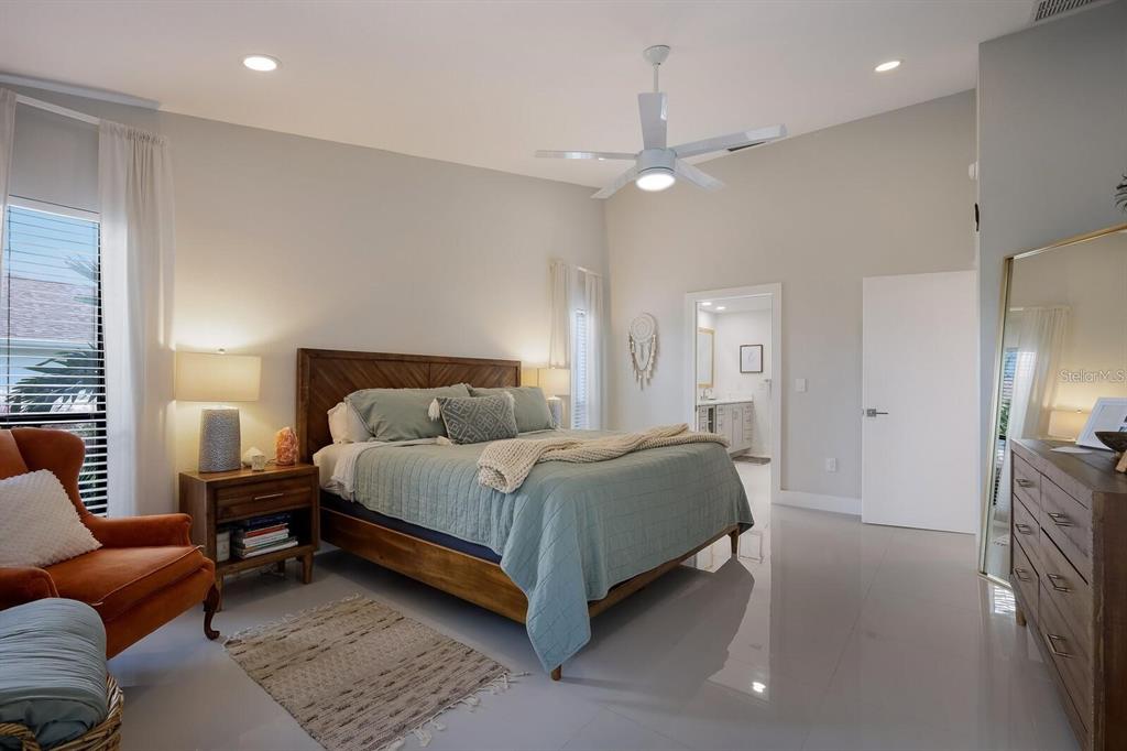 3705 Torrey Pines Boulevard Sarasota, FL 34238 - Photo 17 of 30 a spacious bedroom with a bed a couch and chandelier