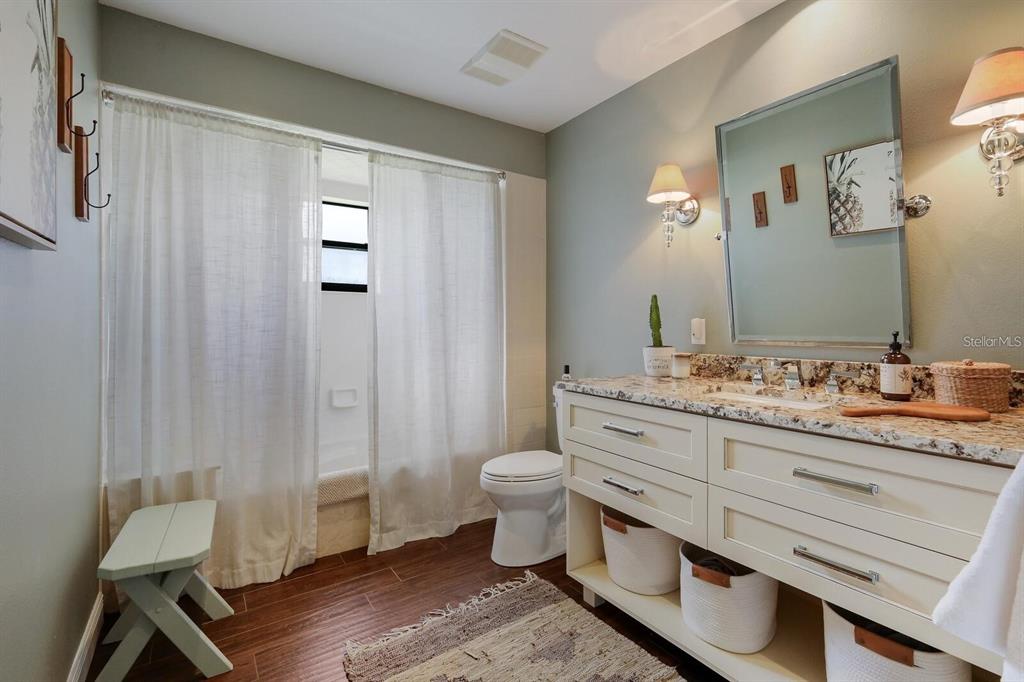 3705 Torrey Pines Boulevard Sarasota, FL 34238 - Photo 22 of 30 a bathroom with a granite countertop toilet sink and mirror