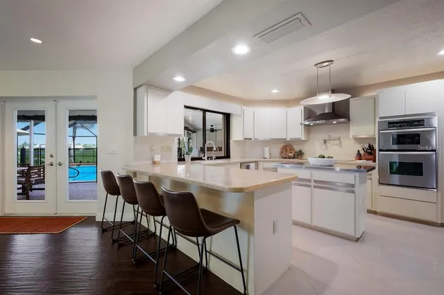 a kitchen with cabinets a sink and chairs in it