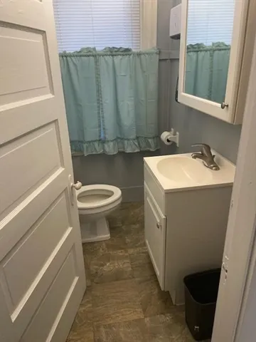 a bathroom with a sink a toilet and a mirror