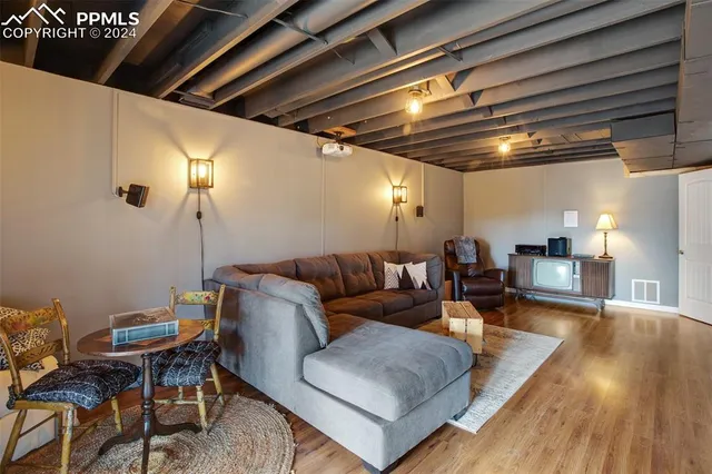 a living room with furniture and a wooden floor