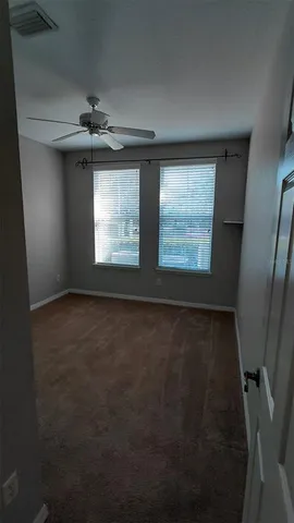 an empty room with windows and fan