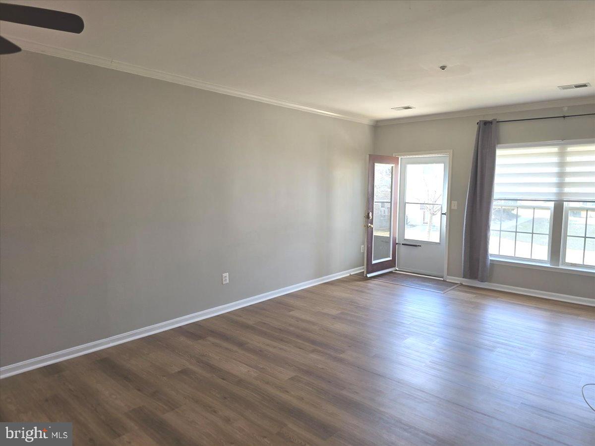 1683 Fallowfield Court Crofton, MD 21114 - Photo 7 of 28 a view of an empty room with wooden floor and a window