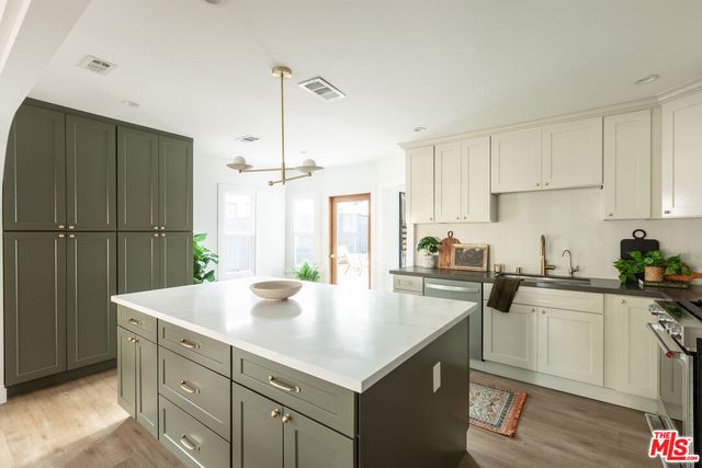 a kitchen with a sink a stove a refrigerator and white cabinets