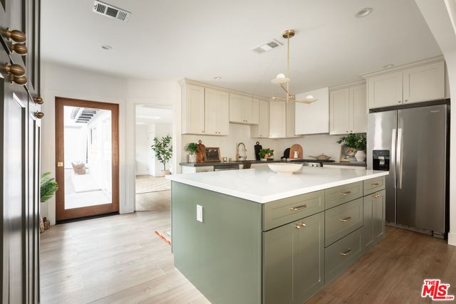 a kitchen with a refrigerator a sink and cabinets