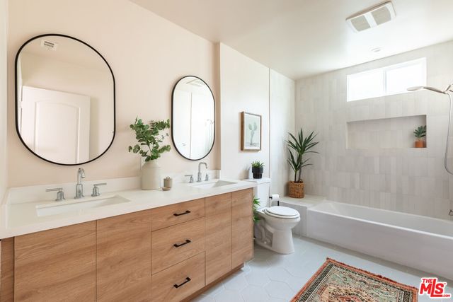 a bathroom with a double vanity sink and a mirror