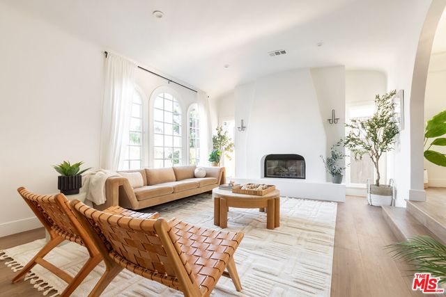 a living room with furniture a fireplace and a large window