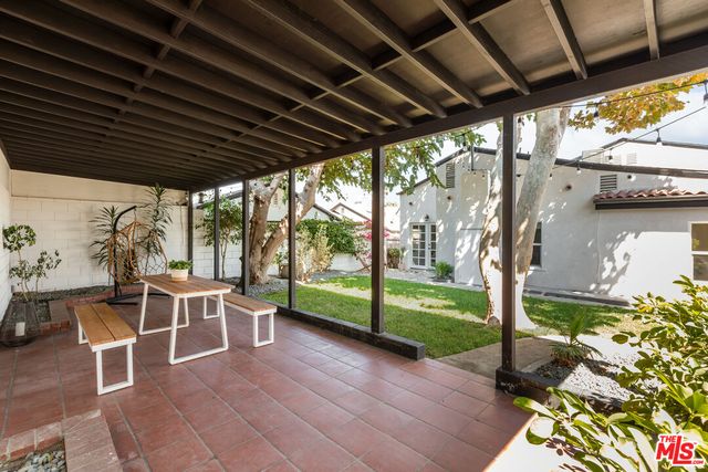a view of a porch with table and chairs and potted plants