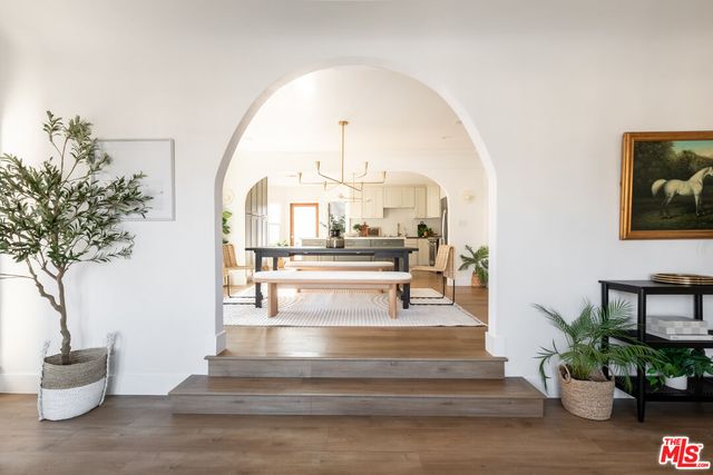 a view of hall way with furniture and a potted plant