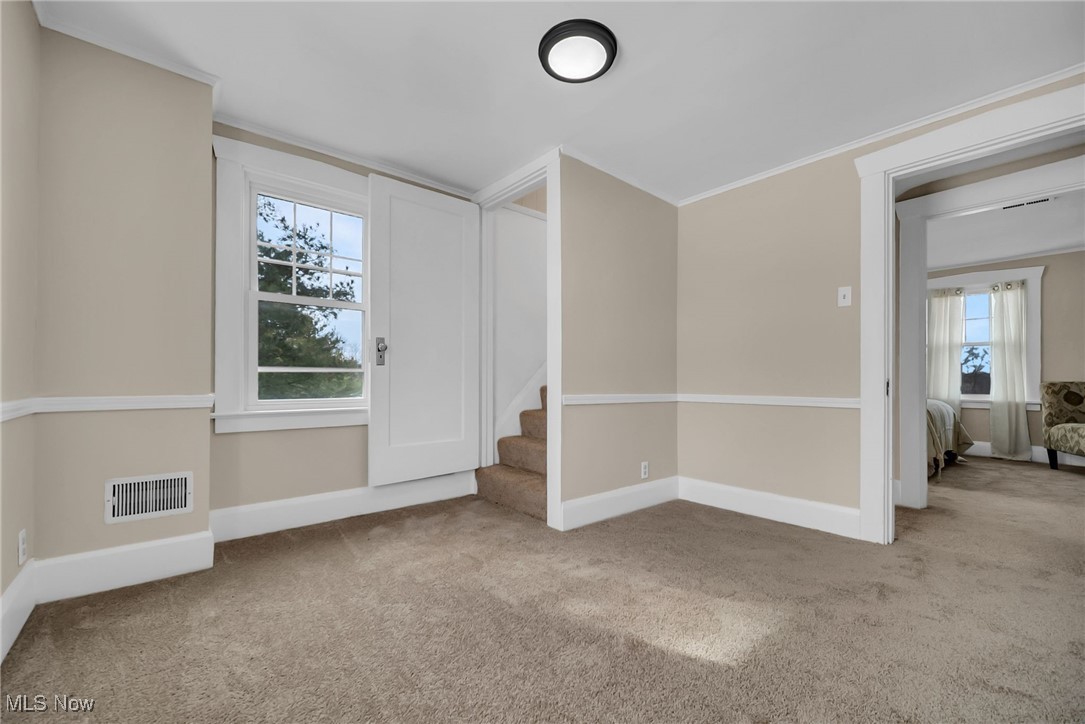 404 Niles Vienna Road Vienna, OH 44473 - Photo 35 of 48 Carpeted entrance foyer featuring stairs, ornamental molding, visible vents, and baseboards