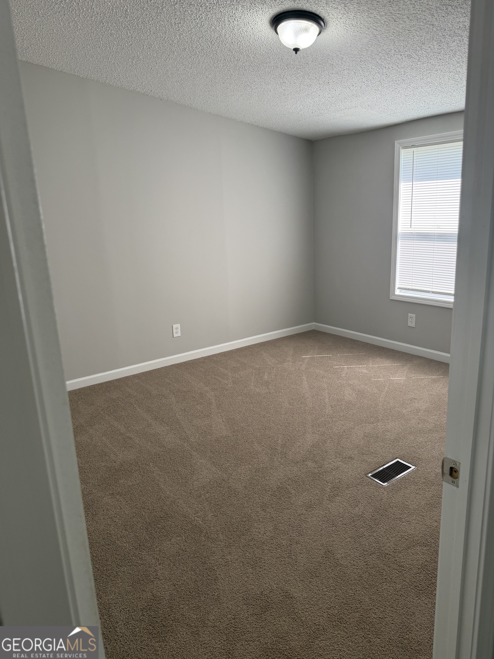 405 Windsor Parkway, Unit 405W Hampton, GA 30228 - Photo 11 of 16 an empty room with a window