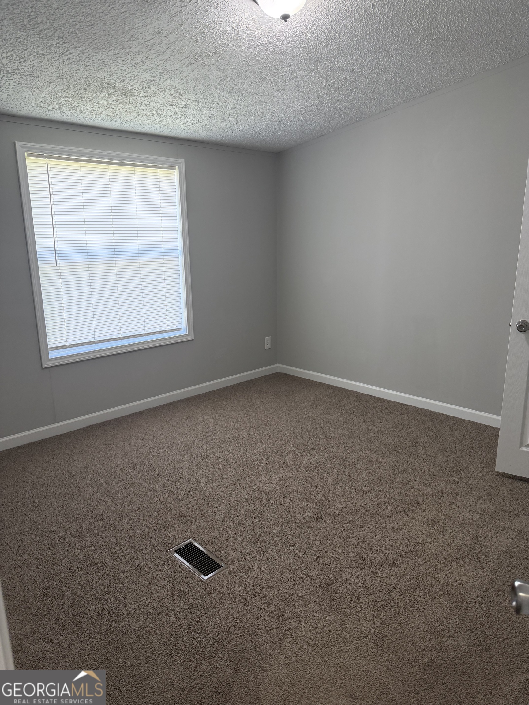 405 Windsor Parkway, Unit 405W Hampton, GA 30228 - Photo 13 of 16 an empty room with a window