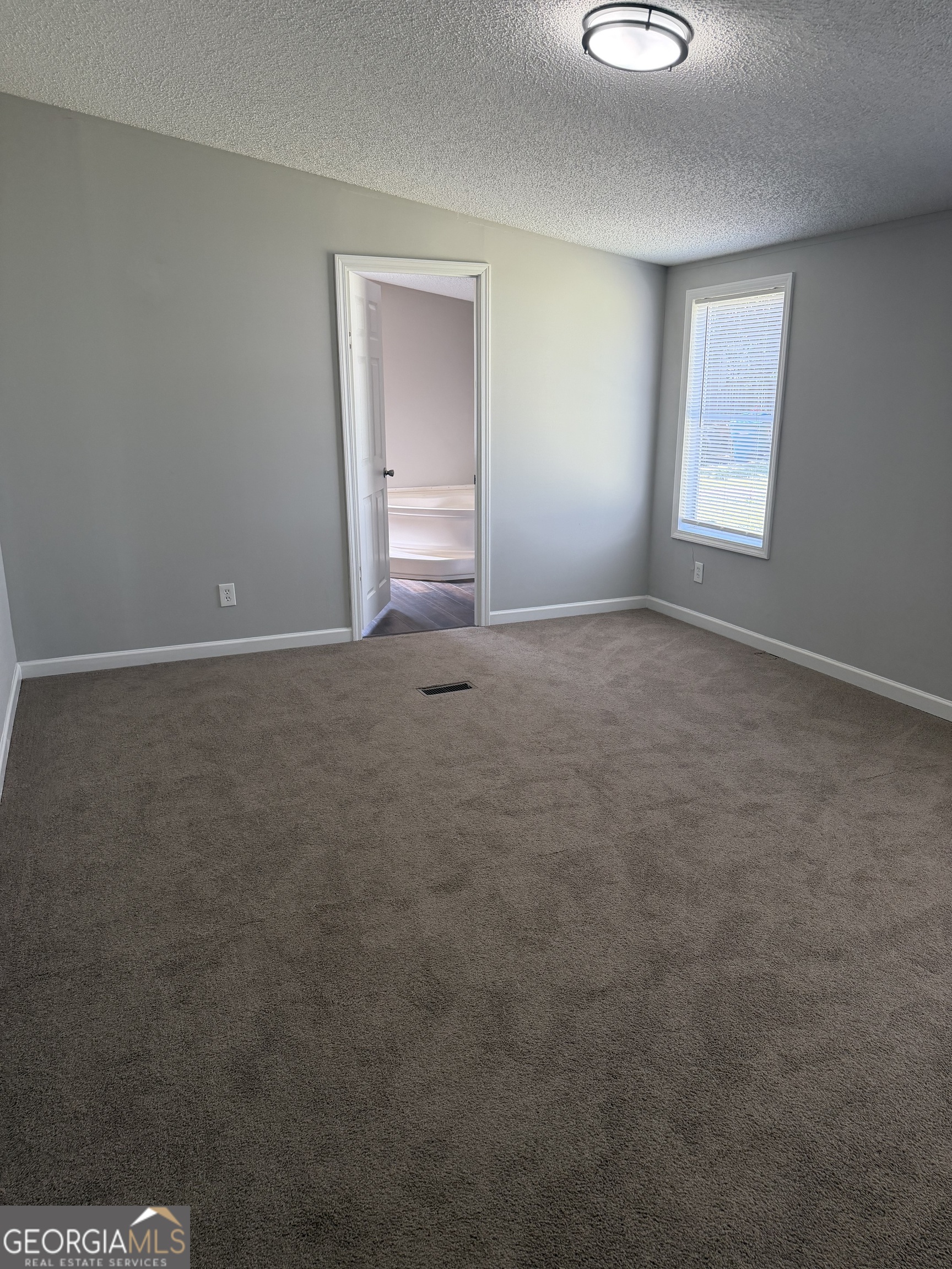 405 Windsor Parkway, Unit 405W Hampton, GA 30228 - Photo 10 of 16 a view of an empty room with a window