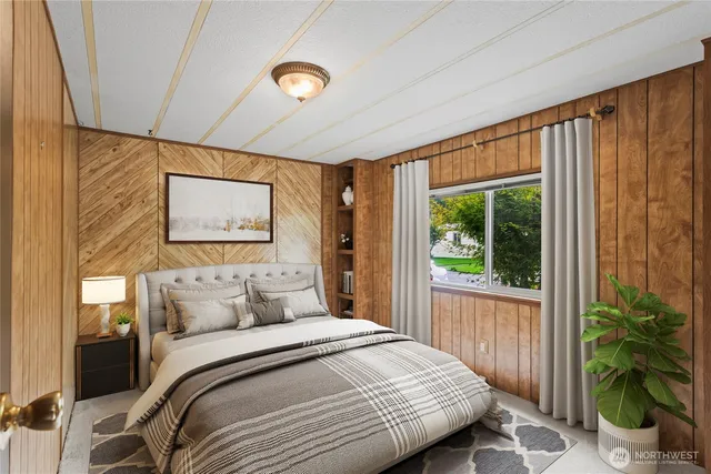 a bedroom with a bed and a large window