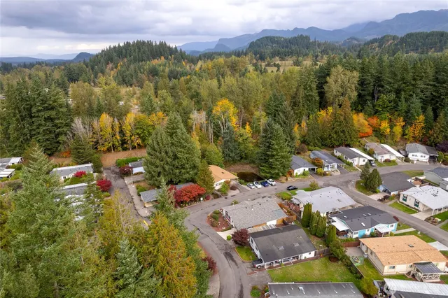 an aerial view of a houses with a lush green hillside