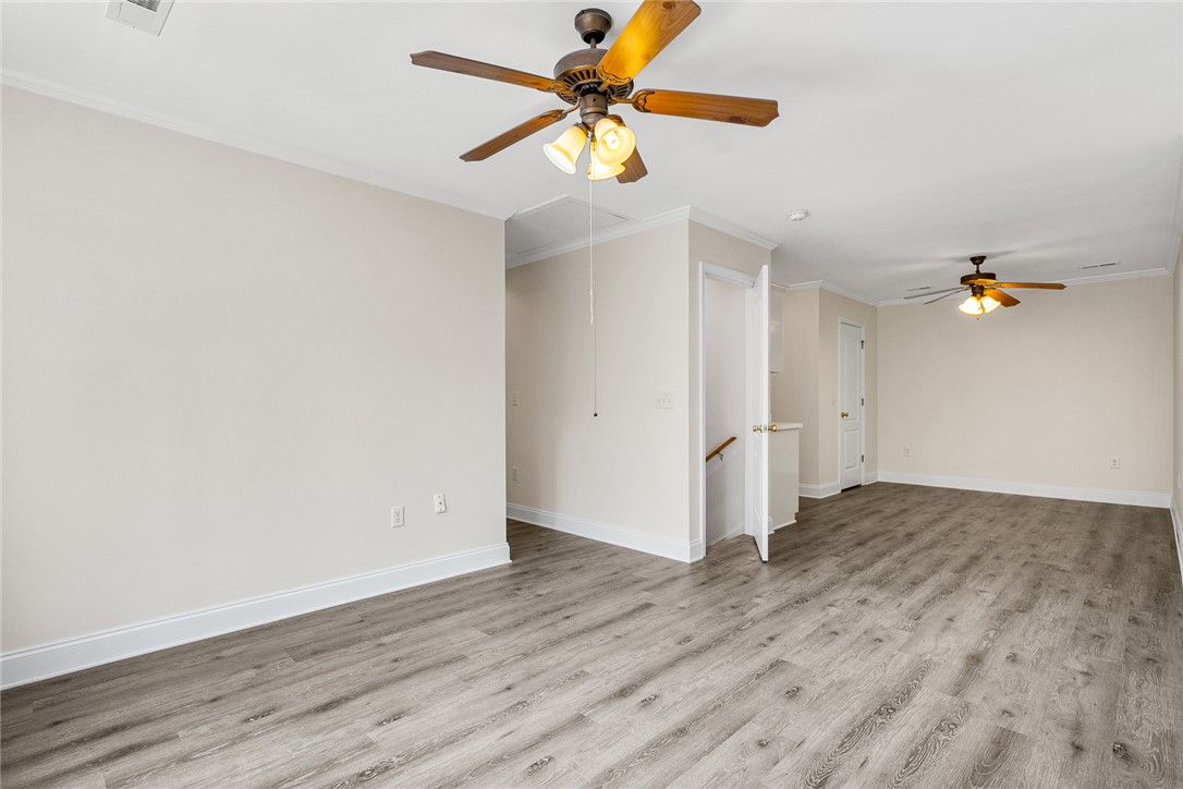 135 Sunset Bay Boulevard Seneca, SC 29672 - Photo 35 of 50 A spacious, airy room features light wood-look flooring and multiple ceiling fans.