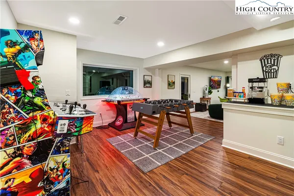 a room with furniture pool table and a flat screen tv