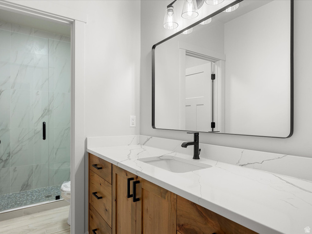1159 North Broad Hollow Road Garden City, UT 84028 - Photo 50 of 55 Contemporary bathroom featuring a wood-finish vanity with matte black hardware, a rectangular undermount sink, and a white countertop with subtle veining