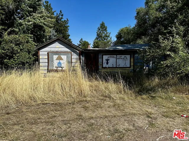 a view of a wooden house next to a yard