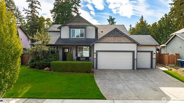 a front view of a house with a garden and trees