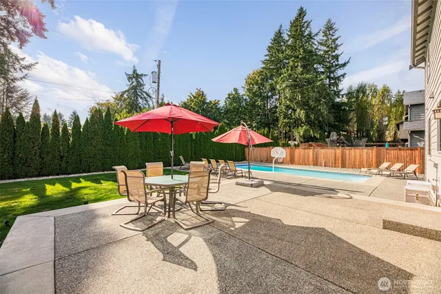 a patio with a table and chairs under an umbrella