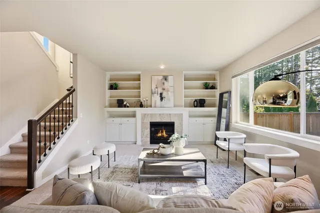 a living room with furniture a fireplace and a large window