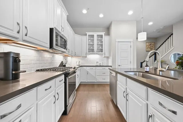 a kitchen with stainless steel appliances granite countertop a sink stove and cabinets
