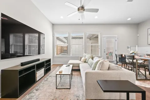 a living room with furniture windows and a kitchen view