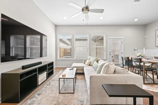 a living room with furniture windows and a kitchen view