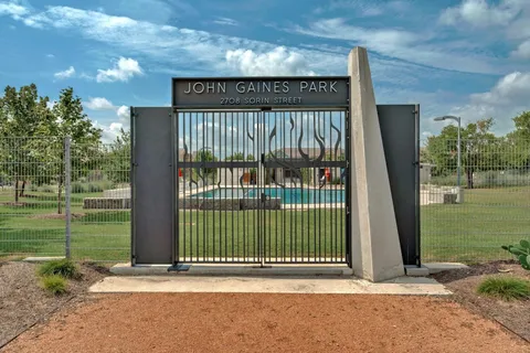 a view of a entrance gate of the house and trees