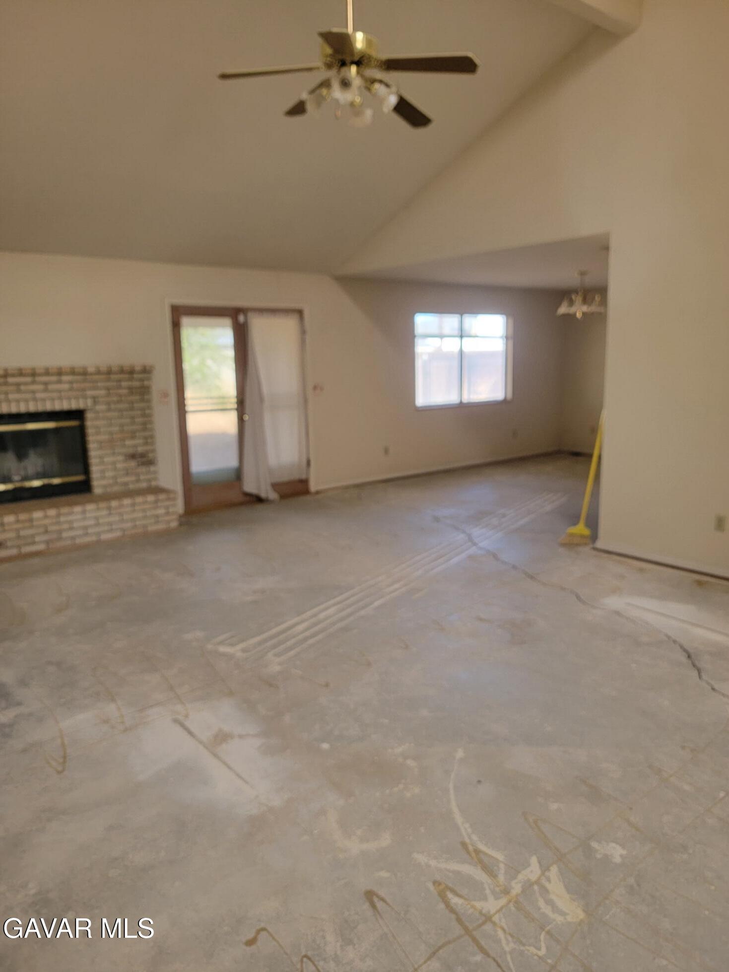 21481 Randsburg Mojave Road California City, CA 93505 - Photo 11 of 28 an empty room with windows and fireplace