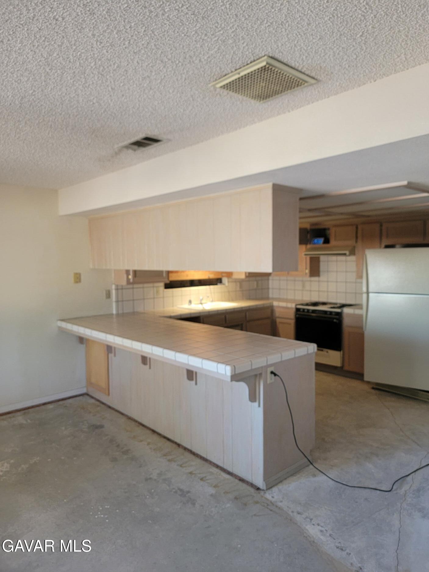 21481 Randsburg Mojave Road California City, CA 93505 - Photo 13 of 28 a kitchen with stainless steel appliances a sink and a refrigerator