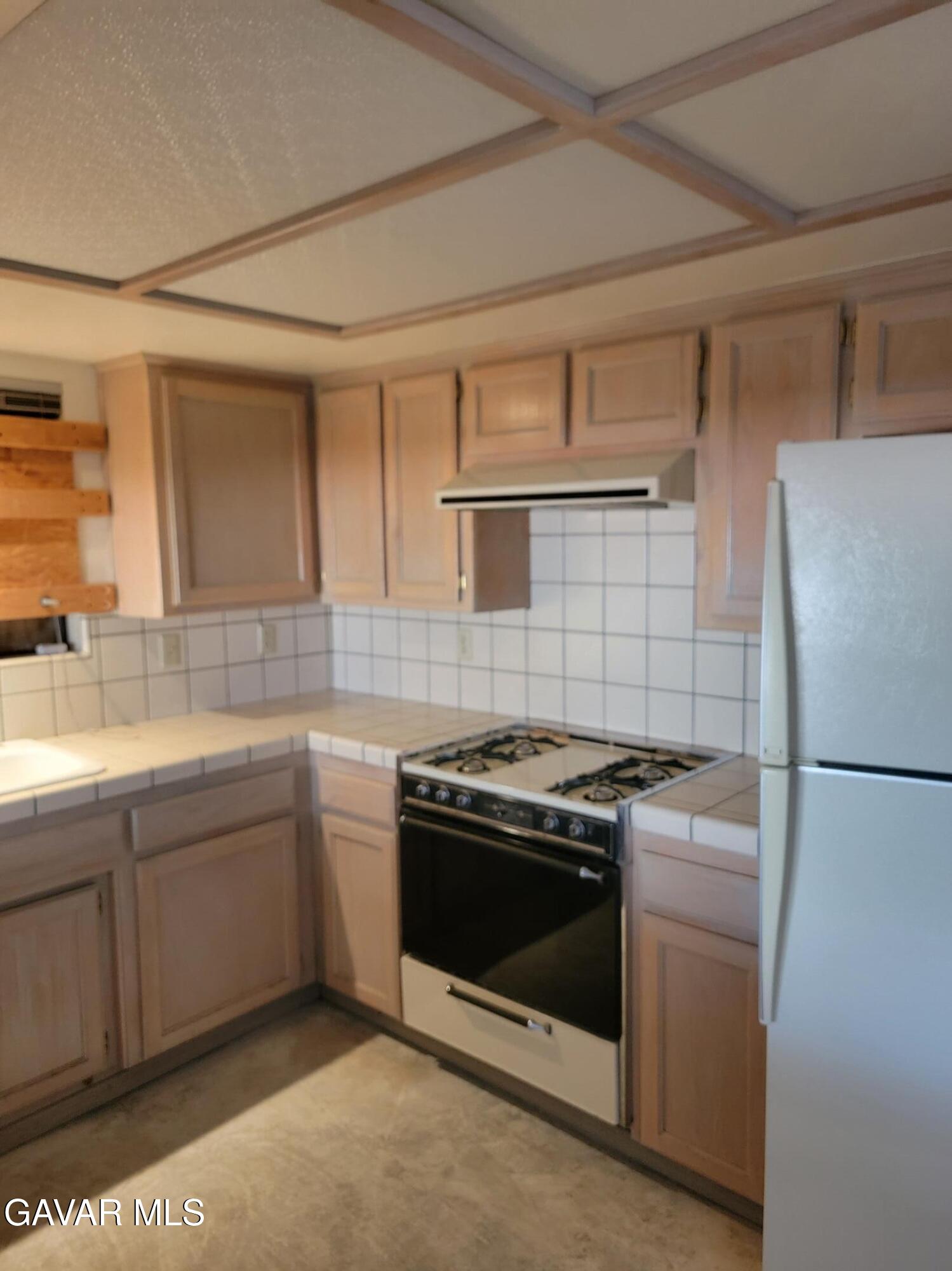 21481 Randsburg Mojave Road California City, CA 93505 - Photo 15 of 28 a kitchen with a stove top oven and refrigerator